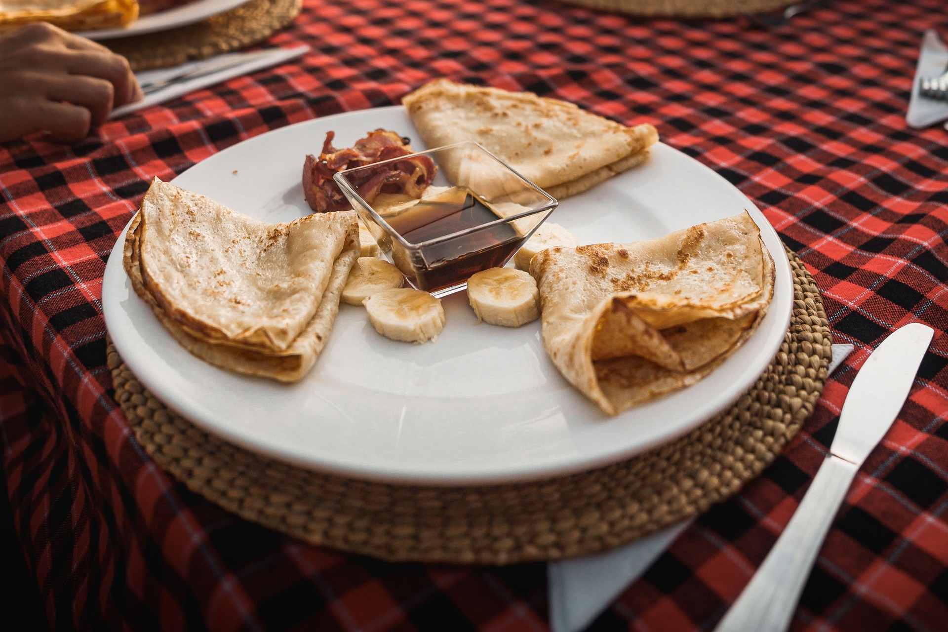 Tourists having pancakes with sliced banana, bacon and maple syrup for breakfast in tanzania