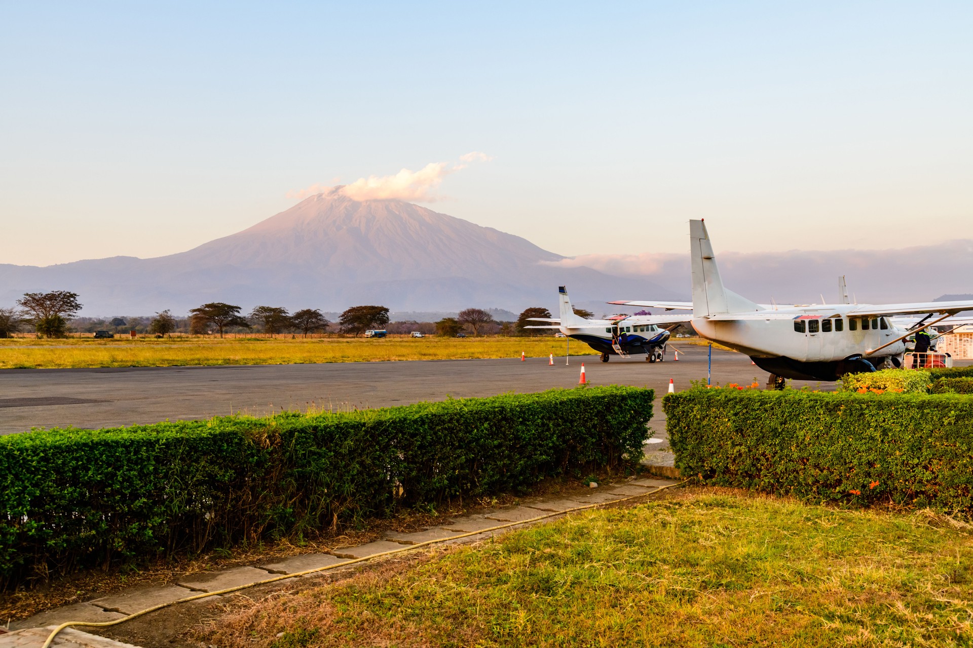 Small propeller airplanes at the airport at sunset, mount Meru at background. Arusha, Tanzania